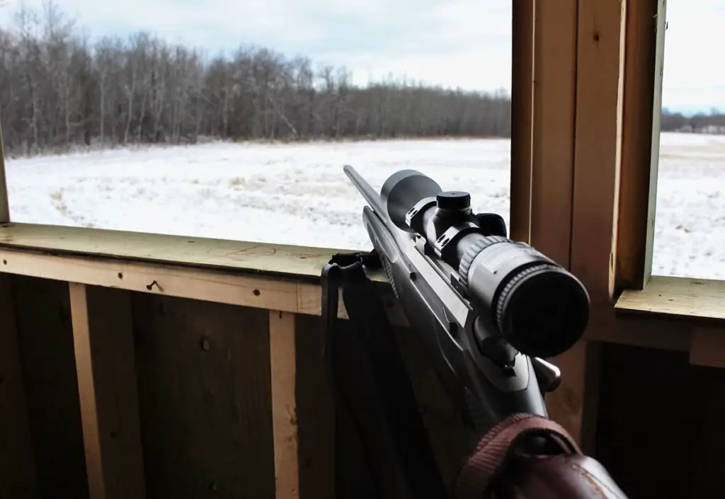 Rifle resting on a deer stand for hunting