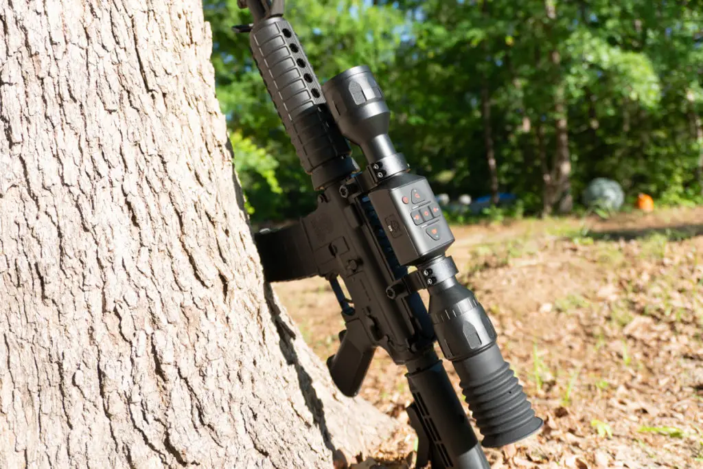 ATN Thor LT Thermal scope on an ar-15 rifle leaning on a tree