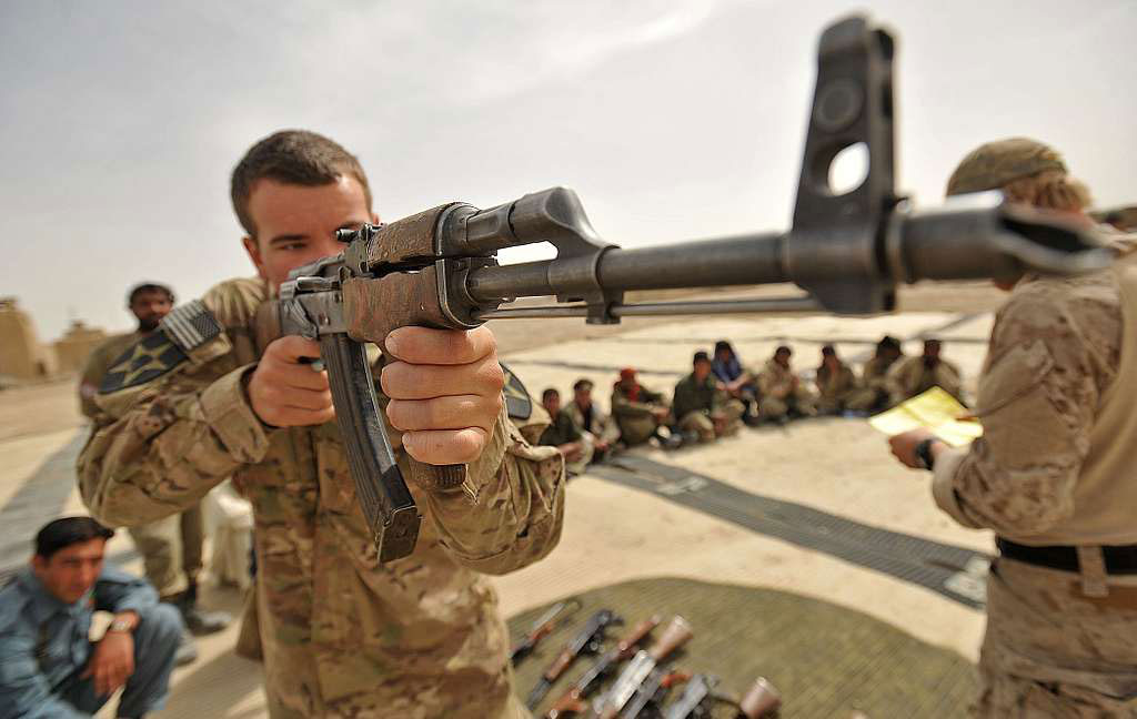 US military member teaching Afghan Police how to fire AK47
