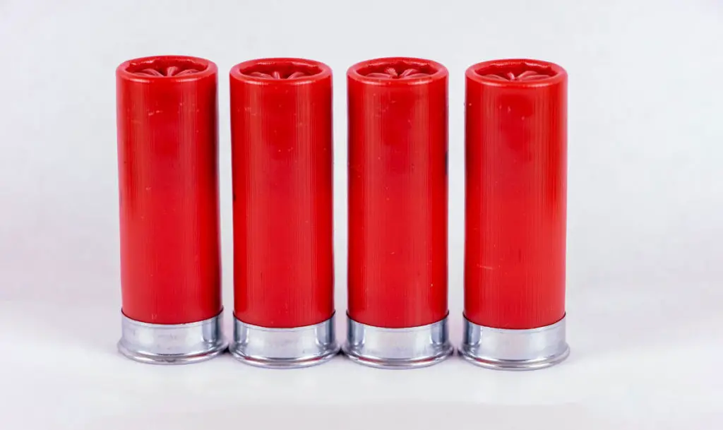 Four red shotgun shells standing on a table