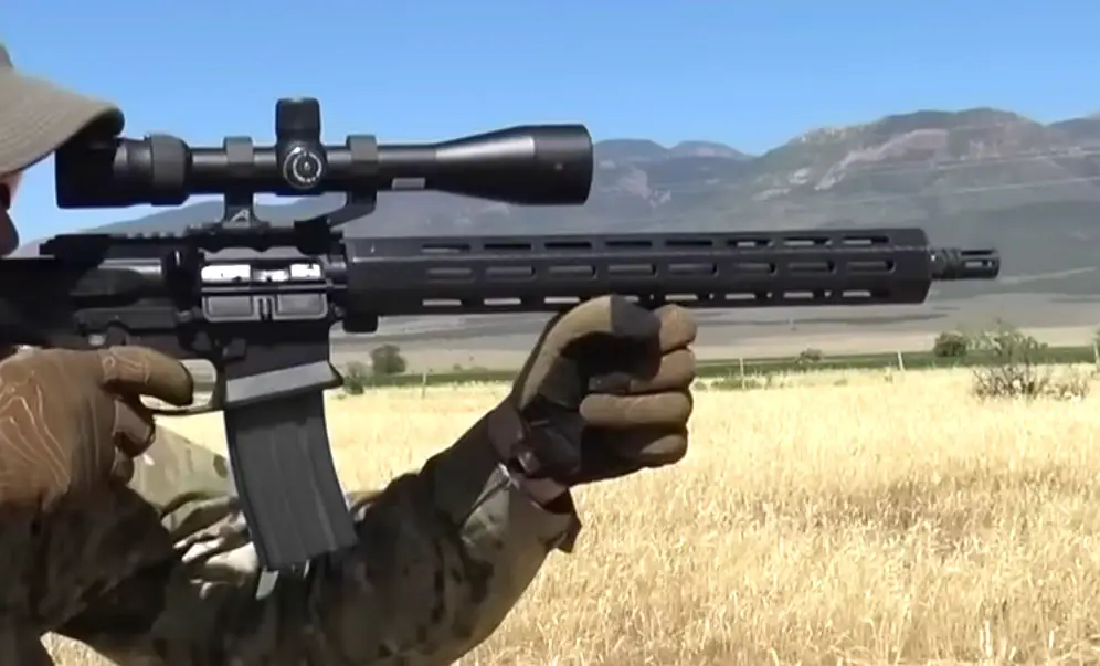 WWSD AR-15 Carbine being shot by a man in a field with a mounted scope
