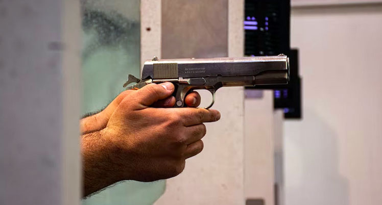 Side view of a man holding a pistol