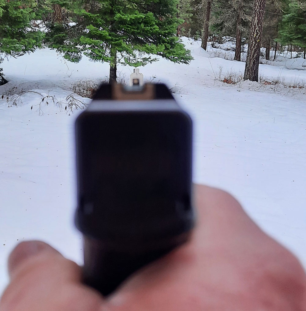 Firing at a target in the snow with glock 22 iron sights