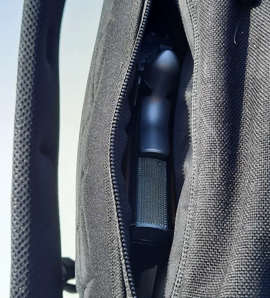 Pistol tucked into concealed carry compartment of sling