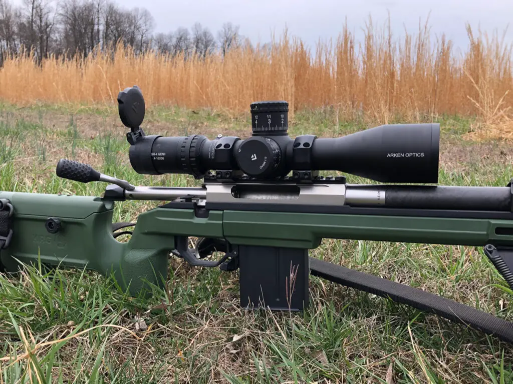 Ready to shoot Arken Optics SH4 GenII scope in a field on a rifle